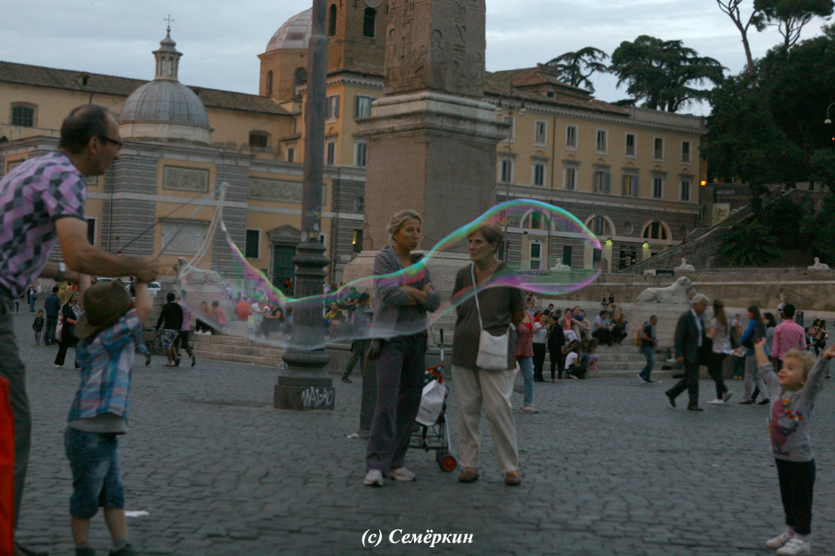 Рим - Мужчина и мальчик запускают огромные мыльные пузыри на Народной площади