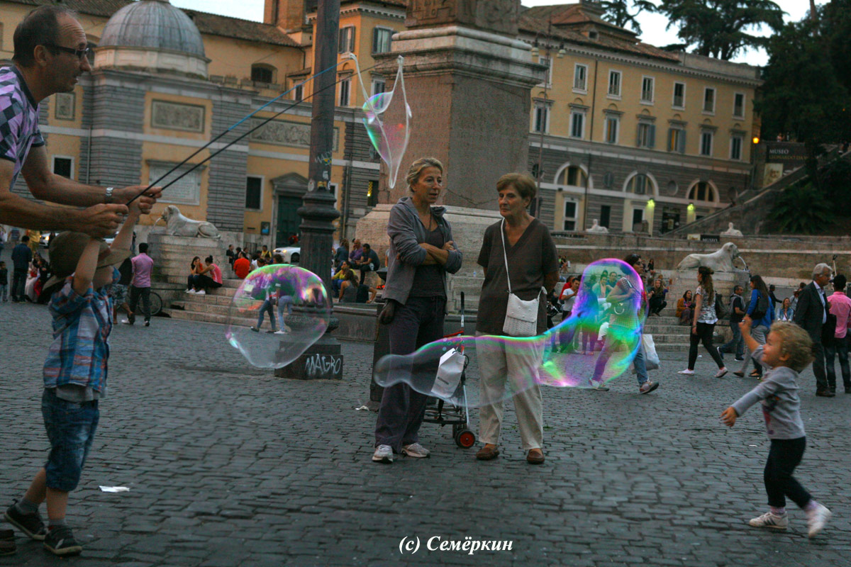 Рим - Мужчина и мальчик запускают огромные мыльные пузыри на Народной площади
