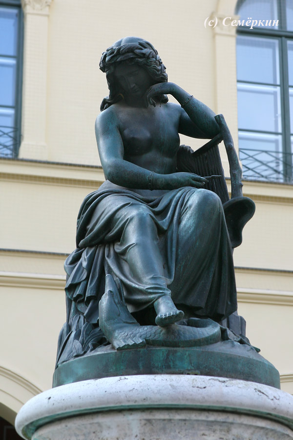 Мюнхен Достопримечательности - Женщина (грудь обнажена) с арфой и щукой